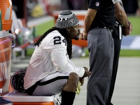 Oakland Raiders running back Marshawn Lynch (24) sits during the national anthem prior to the team's NFL preseason football game against the Arizona Cardinals, Saturday, Aug. 12, 2017, in Glendale, Ariz.