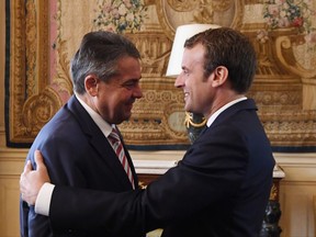 French President Emmanuel Macron, right, greets German Vice Chancellor and German Foreign Minister Sigmar Gabriel upon his arrival at the Elysee presidential Palace in Paris, France, Wednesday, Aug. 30, 2017. (Alain Jocard/Pool Photo via AP)