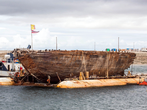 Explorer Roald Amundsen's ship, the Maud, on the barge that will float her back to Norway and the tug that will haul her.