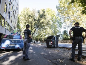 Italian police officers stand near the site where a trash bin was removed after two amputated legs were found in Rome, Wednesday, Aug. 16, 2017. According to the Italian Police first investigations the part of the human body found belongs to a woman. (Angelo Carconi/ANSA via AP)