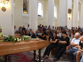 People attend the funeral service of Luigi and Aurelio Luciani, two brothers who were killed by gunmen after they apparently witnessed other two murders, in the southern Italian town of San Marco in Lamis, Friday, Aug. 11, 2017. Italian news agency ANSA quoted investigators as saying that the brothers were chased down by four of five killers and shot to death. (Franco Cautillo/ANSA via AP)