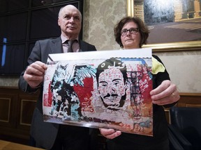 FILE - In this Monday, April 3, 2017 file photo, Giulio, left, and Paola Regeni, the parents of Giulio Regeni, an Italian graduate student tortured to death in Egypt, shows a pictures of a murales depicting their son as they meet the media during a press conference in Rome. (Massimo Percossi/ANSA via AP)