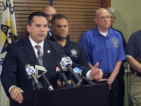 Jason Pappas, left, president of the Fraternal Order of Police Capital City Lodge No. 9, explains a no-confidence vote taken by Columbus officers against the city's mayor, city council president and safety-service director, at a news conference attended by several other union officials, on Friday, Aug. 11, 2017, in Columbus, Ohio. Pappas said the vote expressed dissatisfaction over the firing of an officer seen on a video kicking a suspect, but also over concerns the city doesn't have enough officers to deal with the city's rising homicide rate and record drug overdoses. (AP Photo/Andrew Welsh-Huggins)