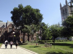 People walk on the Trinity College campus, Tuesday, Aug. 1, 2017, in Hartford, Conn. A former student is suing the private college after being suspended for cheating. The student, who graduated earlier this year, is seeking to use a pseudonym in the lawsuit to remain anonymous. Trinity's lawyer said allowing students to sue schools anonymously over disciplinary matters would create a "groundswell" of litigation. (AP Photo/Dave Collins)