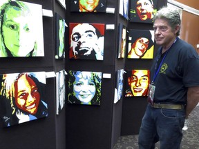 In this Thursday, Aug. 10, 2017 photo, Joe Fitzpatrick looks at a portrait of his daughter, Molly, who died of a drug overdose in 2015, as he attends a reception for artist Anne Marie Zanfagna at the New Hampshire State Library in Concord, N.H. Fitzpatrick said it was "overwhelming" to see his daughter's image alongside more than 80 others the artist painted of those who have died during New Hampshire's opioid epidemic. (AP Photo/Holly Ramer)