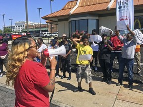In this Thursday, Aug. 24, 2017, photo, Gennice Mackey uses a bullhorn to lead a chant of "Save the Raise!" outside a McDonald's restaurant in St. Louis. A Missouri law that takes effect Monday, Aug. 28, prohibits cities from having a higher minimum wage than the state's wage of $7.70 per hour. That means St. Louis' $10 minimum wage will be rolled back. But advocates of a higher wage are urging employers to keep the $10 minimum wage. (AP Photo/Jim Salter)