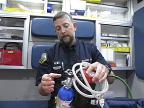 In this Tuesday, Aug. 15, 2017, photo, Scott Brinkman, chief of Stowe Department of Emergency Medical Services, demonstrates how nitrous oxide is used in an ambulance, in Stowe, Vt. Several rural ambulance crews are using nitrous oxide, or laughing gas, to treat patients' pain en route to the hospital when paramedics aren't on board to provide narcotics. (AP Photo/Lisa Rathke)