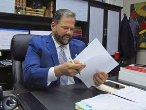 In this Aug. 14, 2017 photo, Immigration attorney Raed Gonzalez looks over files in his office in Houston. Gonzalez is one of a handful of lawyers in Texas who assist victims of immigration fraud in filing complaints against their old lawyers, helping people who often struggle to navigate the legal system. (AP Photo by Nomaan Merchant)