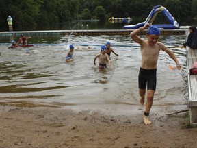 Swimmers exit the water at the fourth annual Race4Chase kids triathlon finale in Southington, Conn. on Saturday, Aug. 5, 2017. The program, founded by the family of a Chase Kowalski, who was killed in the Sandy Hook shootings has grown to more than 20 sites in three states. (AP Photo/Pat Eaton-Robb)