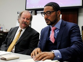 CORRECTS SPELLING OF LAST NAME TO MONNETT FROM MONETTE - Attorneys Charles Monette, left and Justin Bamberg, chat prior to a citizens review board hearing in Charlotte, N.C., on Tuesday, Aug. 8, 2017. The attorneys represent the estate of Keith Lamont Scott, who was shot and killed by a Charlotte-Mecklenburg police officer last September. The board said it found potential error in the departments decision that the shooting was justified and convened a second hearing to address the finding. (AP Photo/Skip Foreman)