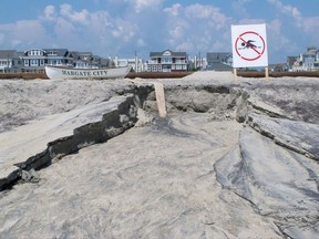 In this Wednesday, Aug. 2, 2017 file photo, sand is eroded away on the beach in Margate N.J. after water from one of three large ponds on the beach was pumped out to sea. On Tuesday, Aug. 22, 2017 a federal appeals court refused to halt the project in Margate. Residents named the bacteria-laden water that pooled after a storm "Lake Christie."The dune project resumed in Margate last weekend after a federal judge overruled a state judge's decision to stop it.Margate homeowner Anne Rubin says that the project has made going to the beach like going to a construction site. (AP Photo/Wayne Parry, File)