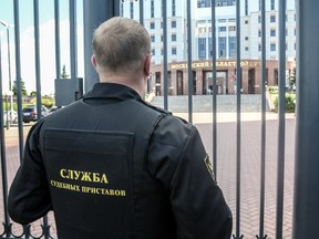 A bailiff stands behind a fence at the main entrance of Moscow Regional Court is seen in Moscow, Russia, Tuesday, Aug. 1, 2017.