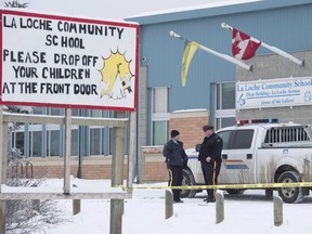 Members of the RCMP stand outside the La Loche Community School in La Loche, Sask., on Jan. 25, 2016. Final submissions are to scheduled today at the sentencing hearing for a teenager who shot and killed four people and injured seven others at a home and a high school in northern Saskatchewan