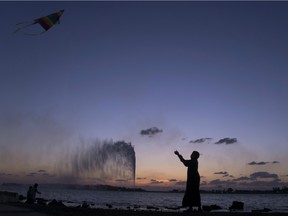 A boy flies a kite on the Red Sea beach near the landmark Jiddah fountain, in Jiddah, Saudi Arabia.
