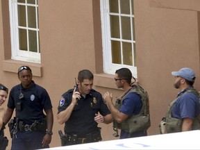 Police gather near the scene of a reported shooting in Charleston, S.C., on Thursday, Aug.24, 2017.  Authorities say a disgruntled employee shot one person and is holding hostages in a restaurant in an area that is popular with tourists. Mayor John Tecklenburg said at a news conference that the shooting was not an act of terrorism or racism. (Grace Beahm Alford /The Post And Courier via AP)