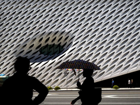 A woman with an umbrella walks past the Broad Museum during a heat wave in July 2016 in Los Angeles.