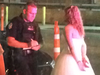 A photo taken by Twitter user IAmByks showing the bride, handcuffed, speaking with police outside the bar.