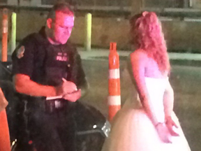 A photo taken by Twitter user IAmByks showing the bride, handcuffed, speaking with police outside the bar.