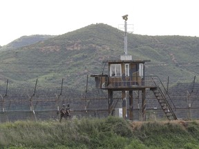 South Korean army soldiers patrol along the barbed-wire fence in South Korea's Paju near the border with North Korea, Friday, Aug. 11, 2017. Military officials said Friday they plan to move ahead with large-scale U.S.-South Korea exercises later this month that North Korea, now finalizing plans to launch a salvo of missiles toward Guam, claims are a rehearsal for war. (AP Photo/Ahn Young-joon)