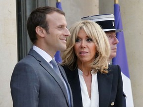 FILE- In this July 20, 2017 file photo, French President Emmanuel Macron, left, and his wife Brigitte Macron await for a diner at the Elysee Palace in Paris, France. French President Emmanuel Macron wants to formalize the role of the president's wife amid controversy over the cost and status of the first lady. The president's office is preparing a formal communication in coming days, Brigitte Macron's office said Tuesday. As Macron's popularity drops in polls, more than 270,000 people have signed a petition in the past few weeks against the plan to grant a tax-funded budget to finance the president's wife activities. (AP Photo/Michel Euler, File)