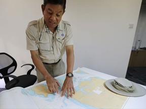 Tan Hua Chiow, a retired Singapore naval officer shows a naval chart and explains to The Associated Press the flow of traffic at sea around the Strait of Singapore on Tuesday, Aug. 22, 2017, in Singapore. Countless ships have made the voyage through one of the world's busiest shipping lane without incident despite its host of navigational challenges, but Monday's pre-dawn collision between a U.S. Navy destroyer and an oil and chemical tanker underlines the risks that normally go unnoticed. (AP Photo/Wong Maye-E)