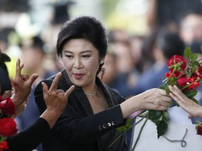 Former Thailand's Prime Minister Yingluck Shinawatra receives flower from her supporters on her arrival at the Supreme Court to make final statement in Bangkok, Thailand, Tuesday, Aug. 1, 2017. Her supporters are gathering outside the court on Tuesday where she is to defend her management of a rice subsidy Thailand's current military government says she grossly mishandled. (AP Photo/Sakchai Lalit)