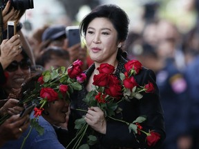 In this Aug. 1, 2017 photo, Thailand's former Prime Minister Yingluck Shinawatra receives flowers from her supporters on her arrival at the Supreme Court to make final statement of the hearing in Bangkok, Thailand. Friends and foes alike of Yingluck Shinawatra, are anxiously awaiting a verdict Friday, Aug. 25, 2017 by the country's Supreme Court on charges that she was criminally negligent in implementing a rice subsidy program that is estimated to have cost the government as much as $17 billion and could now cost her 10 years in prison. (AP Photo/Sakchai Lalit)