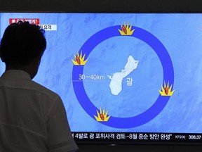 A man watches a TV screen showing a local news program reporting on North Korea's threats to strike Guam with ballistic missiles, at the Seoul Train Station in Seoul, South Korea, Thursday, Aug. 10, 2017.