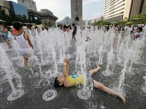 A boy cools himself off in a public water fountain in Seoul, South Korea, on Aug. 1, 2017.