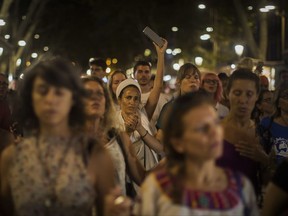 People sing as a protest against the van attack that took place 3 days ago, as they walk across the historic Las Ramblas promenade, Barcelona, Spain, Sunday Aug. 20, 2017.