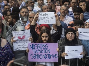 A girl holds a banner that reads: "We are also Victims" during a protest by the Muslim community condemning the attack in Barcelona, Spain, Monday Aug. 21, 2017. The lone fugitive from the Spanish cell that killed 15 people in and near Barcelona was shot to death Monday after he flashed what turned out to be a fake suicide belt at two troopers who confronted him in a vineyard just outside the city he terrorized, authorities said. (AP Photo/Santi Palacios)