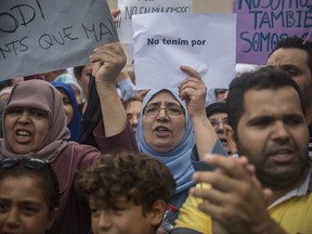 A woman holds a banner that reads in Catalan: "We Don't Fear", during a protest by the Muslim community condemning the attack in Barcelona, Spain, Monday Aug. 21, 2017. The lone fugitive from the Spanish cell that killed 15 people in and near Barcelona was shot to death Monday after he flashed what turned out to be a fake suicide belt at two troopers who confronted him in a vineyard just outside the city he terrorized, authorities said. (AP Photo/Santi Palacios)