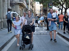 Families flee the scene in Barcelona, Spain, Thursday, Aug. 17, 2017.