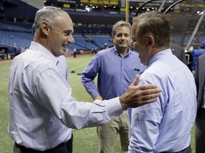 Baseball Commissioner Rob Manfred, left, and Tampa Bay Rays owner Stuart Sternberg, center, meet St. Petersburg Mayor Rick Kriseman before a baseball game between the Rays and the Toronto Blue Jays on Wednesday, Aug. 23, 2017, in St. Petersburg, Fla. (AP Photo/Chris O'Meara)
