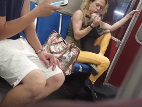 A woman grabs a dog in a screengrab from a video posted to YouTube. She's been charged under animal cruelty laws.