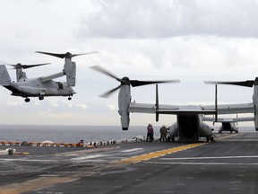 FILE - In this June 29, 2017 file photo U.S. Marine MV-22B Osprey aircraft land on the deck of the USS Bonhomme Richard amphibious assault ship off the coast from Sydney during events marking the start of Talisman Saber 2017, a biennial joint military exercise between the United States and Australia. A MV-22 Osprey that had launched from the USS Bonhomme was conducting regularly scheduled operations when it crashed into the water off Australia's east coast, Saturday, Aug. 5. (Jason Reed/Pool Photo via AP, File)