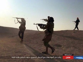 This undated image posted online on Thursday, Aug 24, 2017, purports to show Islamic State fighters firing their weapons during clashes with Syrian troops in south eastern Raqqa, Syria