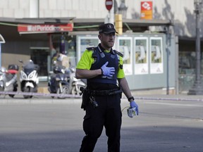 A police officer cordons off a street in Barcelona, Spain, Thursday, Aug. 17, 2017. Police in the northern Spanish city of Barcelona say a white van has jumped the sidewalk in the city's historic Las Ramblas district, injuring several people. (AP Photo/Manu Fernandez)