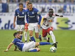 FILE - In this Aug. 19, 2017 file photo Leipzig's Naby Keita, right, and Schalke's Daniel Caligiuri, left, vie for the ball during the German Bundesliga soccer match between FC Schalke 04 and RB Leipzig at the Arena in Gelsenkirchen, Germany. Liverpool has reached an agreement to sign Naby Keita from German club Leipzig, with the Guinea midfielder moving to Anfield at the end of this season. (AP Photo/Martin Meissner)