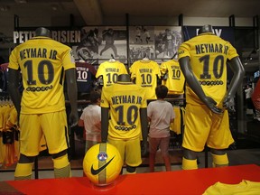PSG soccer shirts bearing the name of Brazilian soccer star Neymar are placed on display in the Paris Saint Germain store in Paris Friday, Aug. 4, 2017. Neymar was set to arrive in Paris on Friday the day after he became the most expensive player in soccer history when completing his blockbuster transfer to Paris Saint-Germain from Barcelona for 222 million euros ($262 million).(AP Photo/Michel Euler)