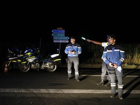 Police officers block a road approaching the town of Sept-Sorts, about 65 kilometers (40 miles) east of Paris, France after an incident when a driver slammed his car into the sidewalk cafe of a pizza restaurant, Monday, Aug. 14, 2017.(AP Photo/Kamil Zihnioglu)