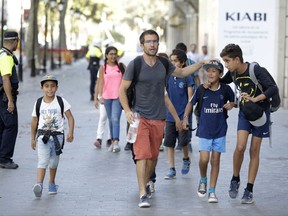 EDS NOTE : SPANISH LAW REQUIRES THAT THE FACES OF MINORS ARE MASKED IN PUBLICATIONS WITHIN SPAIN - Children are escorted down a road in Barcelona, Spain, Thursday, Aug. 17, 2017. Police in Barcelona say a white van has mounted a sidewalk, struck several people in the city's Las Ramblas district. (AP Photo/Manu Fernandez)