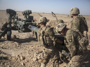 FILE - In this June 10, 2017 photo provided by Operation Resolute Support, U.S. Soldiers with Task Force Iron maneuver an M-777 howitzer, so it can be towed into position at Bost Airfield, Afghanistan.  Reversing his past calls for a speedy exit, U.S. President Donald Trump recommitted the United States to the 16-year-old war in Afghanistan Monday night, Aug. 21, 2017,  declaring U.S. troops must "fight to win." He pointedly declined to disclose how many more troops will be dispatched to wage America's longest war.(U.S. Marine Corps photo by Sgt. Justin T. Updegraff, Operation Resolute Support via AP, File)
