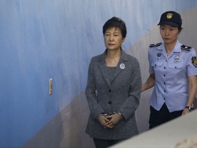Former South Korean President Park Geun-hye, left, arrives for her trial at the Seoul Central District Court in Seoul, South Korea, Friday, Aug. 25, 2017. Samsung heir Lee Jae-yong, the de facto leader of South Korea's most successful business group, was implicated in the massive political scandal that culminated into Park's ouster. (Kim Hong-Ji/Pool Photo via AP)