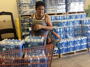 A resident buys bottles of water at Home Depot in Guam Saturday, Aug. 12, 2017. The small U.S. territory of Guam has become a focal point after North Korea's army threatened to use ballistic missiles to create an "enveloping fire" around the island. The exclamation came after President Donald Trump warned Pyongyang of "fire and fury like the world has never seen." (AP Photo/Tassanee Vejpongsa)