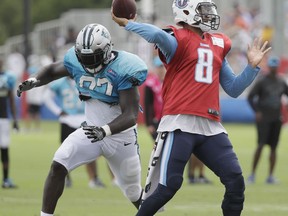 Tennessee Titans quarterback Marcus Mariota (8) passes as he is rushed by Carolina Panthers defensive end Mario Addison (97) during a combined NFL football training camp Thursday, Aug. 17, 2017, in Nashville, Tenn. (AP Photo/Mark Humphrey)