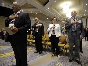 People stand for the Pledge of Allegiance during a meeting of the standing committee on rules at the Republican National Committee summer meeting, Thursday, Aug. 24, 2017, in Nashville, Tenn. (AP Photo/Mark Humphrey)
