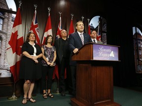 At the Queen's Park media gallery Lisa MacLeod Nepean-Carleton MPP (L) was with Concussion Legacy Foundation (CLF) co-founder and CEO Chris Nowinski, PhD (at podium) and Tim Fleiszer (R), executive director of CLF Canada and four-time Grey Cup Champion, pose out front of Queen's Park with Gordon and Kathleen Stringer - who set up Rowan's  Law, Canada's first concussion legislation - announced a new national concussion awareness campaign designed to protect athletes and improve concussion culture.Tuesday August 15, 2017.