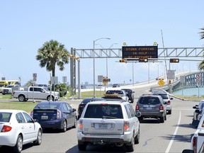 Texas Department of Transportation signage warns drivers to the development of a tropical system on Wednesday, Aug. 23, 2017, in Port Isabel, Texas. Texas Gov. Greg Abbott has ordered the State Operations Center to elevate its readiness level and is making state resources available for preparation and possible rescue and recovery actions amid forecasts a tropical storm will make landfall along the Texas Gulf Coast. (Jason Hoekema/The Brownsville Herald via AP)