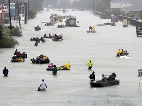 Rescue boats fill a flooded street at flood victims are evacuated as floodwaters from Tropical Storm Harvey rise Monday, Aug. 28, 2017, in Houston.